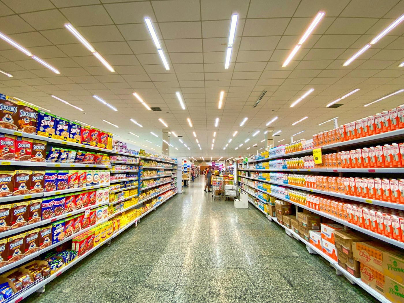 Pasillo de supermercado con estantes surtidos y pisos brillantes